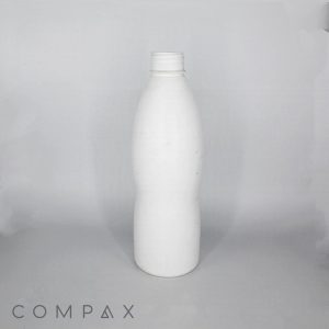 A white, slightly curved plastic bottle with a ridged screw-top cap stands upright on a plain gray surface. The background is a similarly plain, light gray color. The word "COMPAX" is visible along the bottom left corner of the image.
