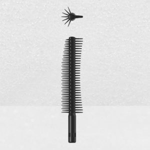 A black Plastic Brush Applicator with a cylindrical shape, featuring closely spaced bristles around its body, is shown on a light grey background. Above the main brush lies a smaller, detachable piece designed for precision styling, also adorned with multiple bristles.