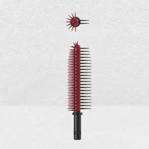 The Plastic Brush Applicator features long and short bristles arranged in a staggered pattern. It has a dark handle, and includes a detachable red, spiked tip that resembles the brush's end, demonstrating its ability to be reassembled.