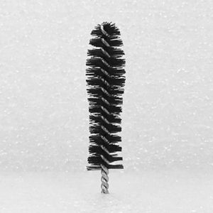 A Nylon Brush Applicator, featuring a vertical black brush with densely packed bristles and a twisted wire handle, set against a white textured background.