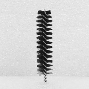 A Nylon Brush Applicator with a black, spiral-shaped head featuring closely packed bristles stands upright against a textured white background. The brush is equipped with a twisted metal handle.