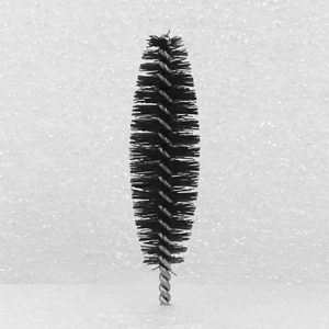 A Nylon Brush Applicator with dense bristles, captured against a softly textured white background. The applicator is vertically positioned, highlighting its cylindrical shape and spiral design.