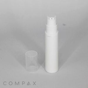 A white, cylindrical pump bottle with a clear plastic cap off and placed beside it, standing on a plain gray surface. The logo "COMPAX" is visible in the bottom left corner.