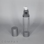 A clear, cylindrical pump bottle with a silver base and cap. The cap is removed, placed beside the bottle, and reveals a white pump dispenser. The background is plain, and the brand name "COMPAX" is visible in the bottom left corner.