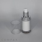 A white Double Wall Airless Bottle featuring a silver neck and pump, accompanied by a clear plastic cap placed beside it. The bottle is set against a plain light gray background, with the word "COMPAX" faintly visible in the bottom left corner.