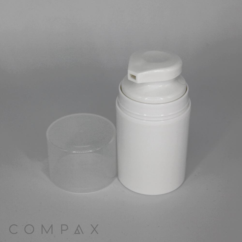 A white pump bottle with a clear plastic lid removed, showing the pump dispenser. The bottle stands against a plain, gray background. The word "COMPAX" is faintly visible at the bottom left corner of the image.