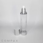 A transparent, cylindrical bottle with a silver pump top and a matching removable cap displayed beside it. The bottle sits on a clean, white surface with the brand name "COMPAX" visible in the bottom left corner.