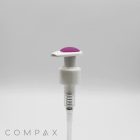 A pump with silicone top featuring a white base and transparent body, highlighted by a purple button on the top, is pictured against a plain, light background. The brand name "COMPAX" is displayed in the lower left corner.
