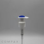 A white plastic pump with a silicone top and spring mechanism is pictured against a plain gray background. The brand name "COMPAX" is visible in faded letters at the bottom left corner of the image.