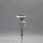 A white, cylindrical pump dispenser featuring a silicone top in light green, likely designed for a bottle. The image has a plain gray background with the word "COMPAX" in the bottom left corner. The dispenser includes a long, transparent tube attached to it.