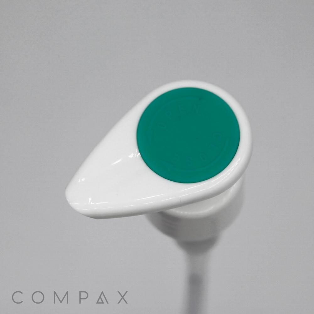 A close-up image of "Pump with Silicone Top", featuring a white dispenser with a green silicone pump head, typically used for liquid products such as soap or lotion. The background is plain and light grey, and the word "COMPAX" is visible in the bottom left corner.