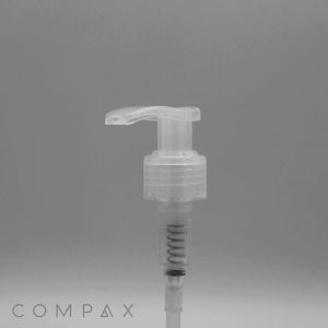 Clear plastic Pump dispenser with a cylindrical base and a slightly curved nozzle, displayed against a plain grey background. The word "COMPAX" appears in the bottom left corner.