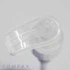 Close-up of a transparent plastic Pump dispenser with its nozzle handle at the top. The background is out of focus, and the word "COMPAX" is partially visible at the bottom left corner of the image.