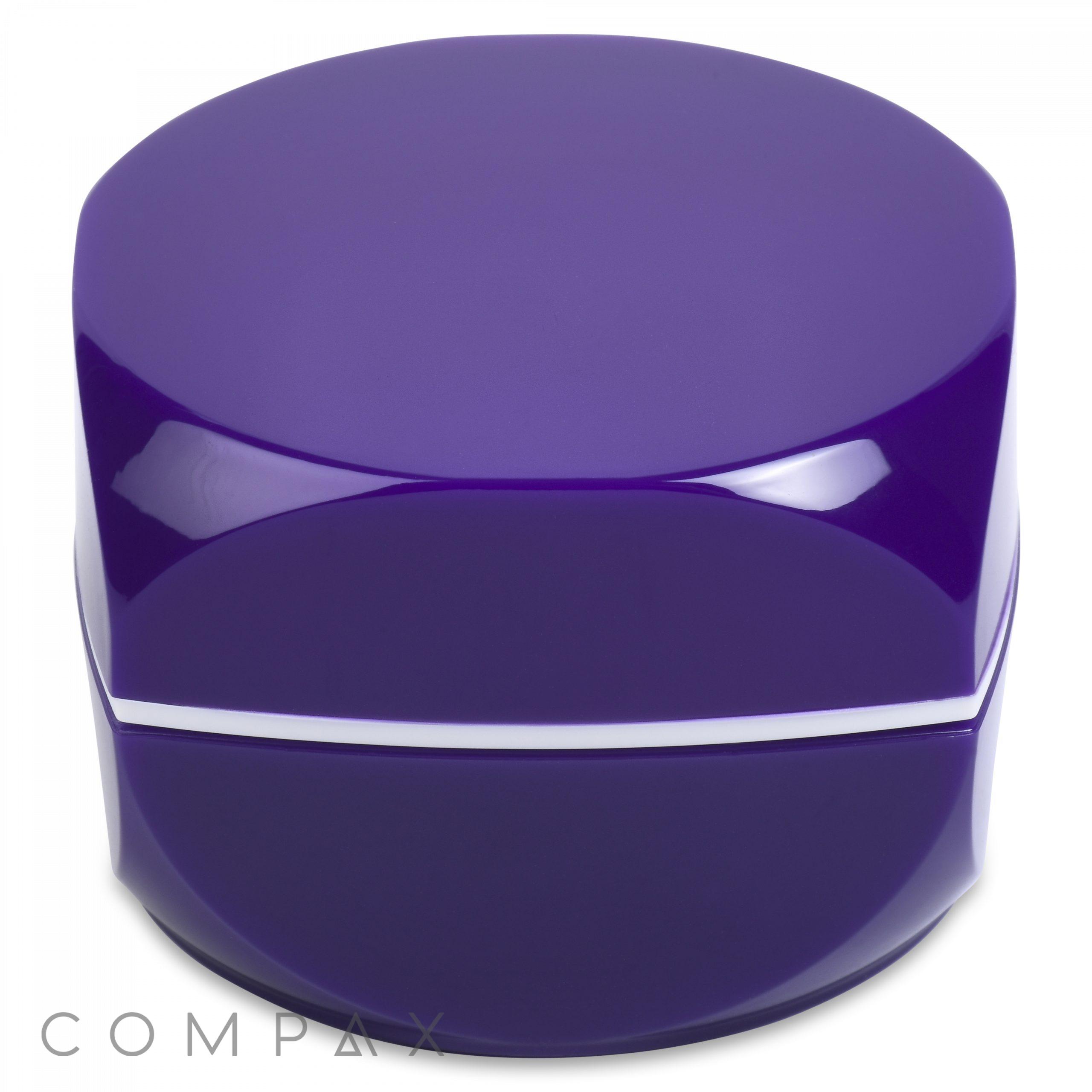 A shiny, round, purple cosmetic container with a smooth, seamless design. The container has a glossy finish and a slight reflection on its surface, indicating a polished look. The brand name "COMPAX" is subtly visible in the lower left corner.