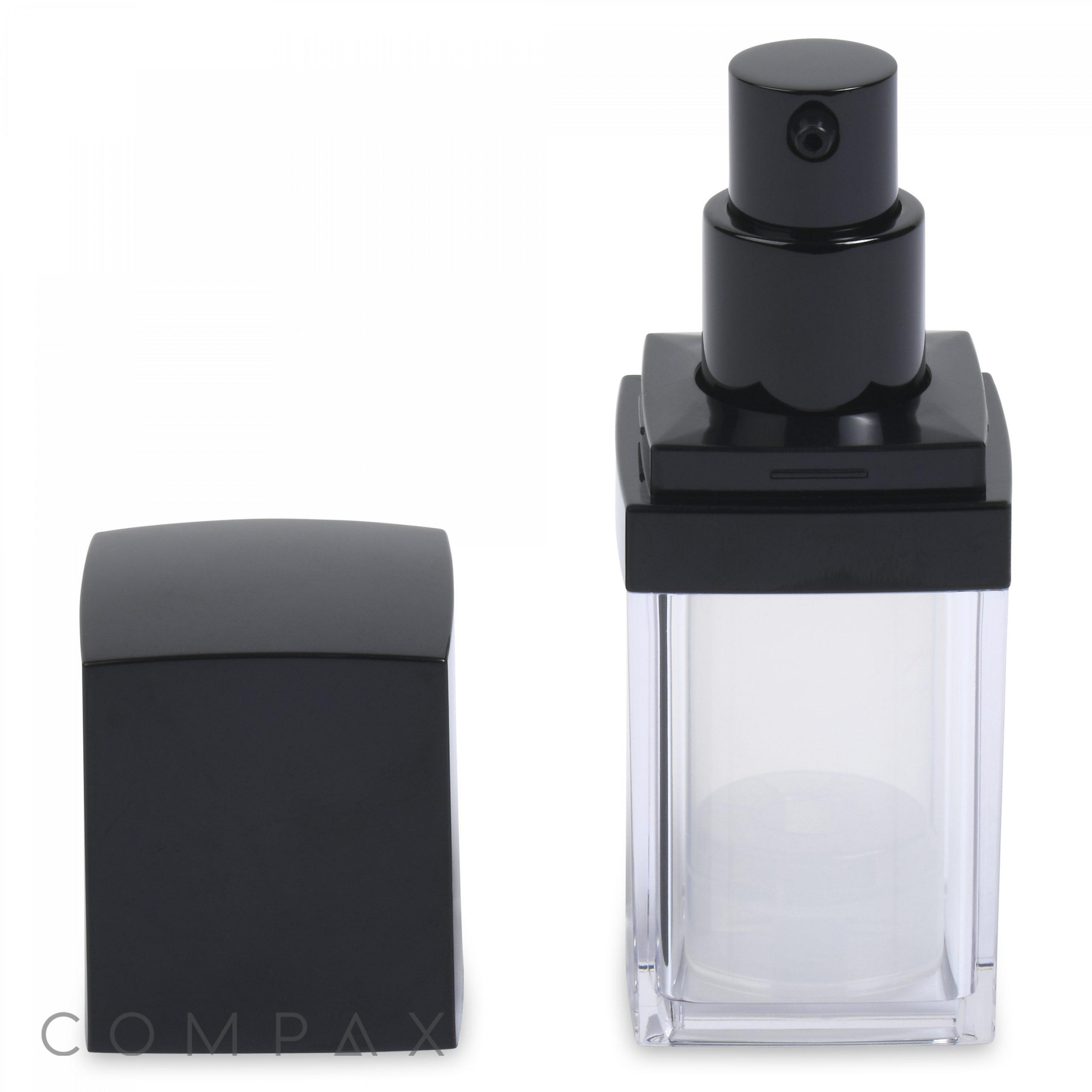A square, transparent Square Double Wall Airless Bottle with a black spray nozzle top, shown with its black cap removed and placed beside it to the left. The bottle is empty, and the brand name "COMPAX" is partially visible in the lower-left corner of the image.