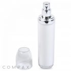 A tall, white Double Wall Airless Bottle with a shiny silver pump dispenser is displayed. The bottle's transparent plastic cap is placed to the left of it. The word "COMPAX" is visible at the bottom left corner of the image. The background is solid white.