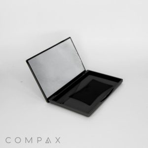 A sleek, empty Rectangular Compact with Mirror is shown open, revealing its reflective upper lid and a plain, unfilled bottom compartment. The word "COMPAX" appears at the bottom left corner on a white background.