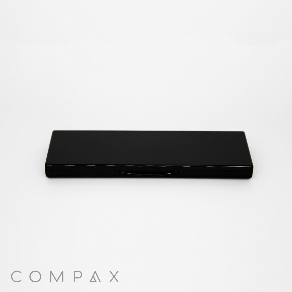A 5 Pan Rectangular Compact in black is centered against a plain white background, with the brand name "COMPAX" visible in the bottom left corner of the image.