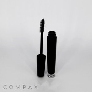 A Fluted Round Mascara Bottle is opened, revealing the mascara wand with bristles. The tube and wand are standing upright on a white background with the brand name "COMPAX" visible at the bottom.
