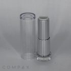 A sleek, silver tube of the Round Textured Lipstick stands upright next to its transparent cap. The brand name "COMPAX" is visible at the bottom-left corner of the image. The modern design features a minimalist aesthetic against a plain, light background.