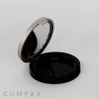 An open Single Well Round Compact in black and silver, featuring a mirror on the inside of the lid. The bottom part of the compact is empty. The word "COMPAX" is printed in gray on the bottom left corner of the image.