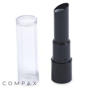 A sleek, black Round Lipstick tube is displayed next to a clear plastic cap. The brand name "COMPAX" is visible in gray text at the bottom left corner. The lipstick is partially extended, showcasing its modern, minimalist design.