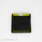 A Single Well Square Compact mirror with a black and yellow-green translucent design is displayed on a white background. The word "COMPAX" is printed in gray at the bottom left corner.