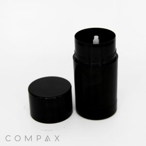 A black cylindrical container with its lid placed next to it. The container is open, revealing a white applicator inside. The word "Round Beauty Stick" is printed in thin gray letters at the bottom left corner of the image. The background is plain white.
