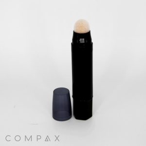 A Round Stick with Blending Applicator, featuring a black design and a detachable cap placed beside it. It has a foam tip for application, and the brand name "COMPAX" is visible at the bottom left corner of the image. The background is plain white.