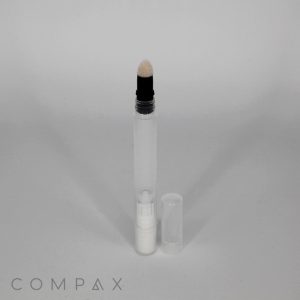 A clear tube of what appears to be a cosmetic or skin care product with a brush applicator at the top. The cap is placed next to the tube on the right. The brand name COMPAX is visible at the bottom left corner of the image. The product is identified as a 3mL Slimline Stick with Blending Applicator.