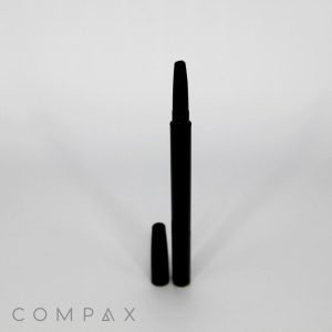 A sleek black cylindrical Round Twist Up Pencil with its cap placed on the surface beside it, standing upright on a grayish-white background. The word "COMPAX" is printed at the bottom left corner of the image in gray text.