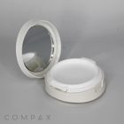 An open Round Cushion Compact with Mirror in a white case, revealing an empty compartment for makeup or powder. The mirror is on the inner lid. The word "COMPAX" appears in the bottom left corner of the image, set against a light grey background.