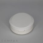 A round, white plastic Round Cushion Compact with Mirror featuring a snap-close lid is centered against a gray background. The word "COMPAX" is printed near the bottom left corner of the image in a minimalist font.