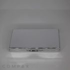 A sleek, silver 3 Well Rectangular Compact case with rounded edges. The case is closed and has a smooth, reflective surface. The word "COMPAX" is faintly visible at the bottom of the image.