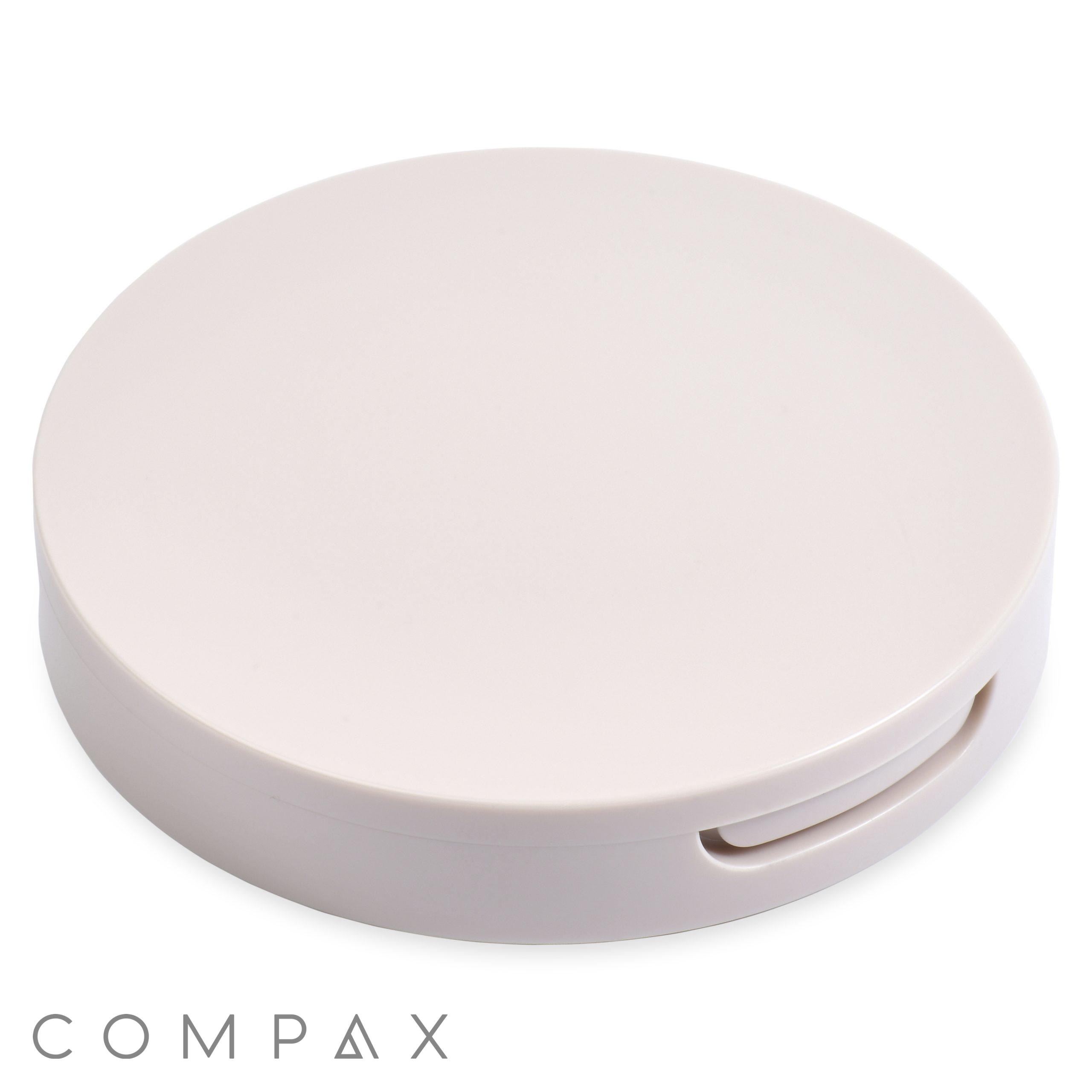 The Single Well Round Compact with Mirror is a round, white plastic case featuring a smooth surface and a small indentation for opening. The word "COMPAX" is written in gray at the bottom left corner. This compact appears to be designed for storing small items or cosmetics.