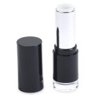 An open black and silver tube of Round Lipstick with the cap placed next to it. The tube is displaying a white or colorless lipstick. The brand name "COMPAX" is visible in gray letters at the bottom left corner of the image.