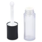 A Mini Round Cosmetic Bottle with Applicator is displayed. The clear, small cylindrical container has a black cap, which is open to reveal a white applicator wand with a round tip. The container stands upright beside the detached cap and is empty. The word "COMPAX" appears in the bottom left corner of the image.