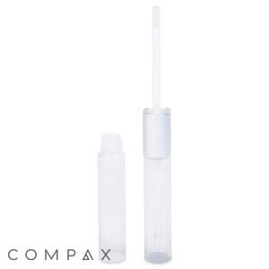 A clear "Round Dual-Sided Lip Gloss" tube with a silver cap, partially unscrewed and standing next to the tube. The tube is empty, and the attached applicator stick is visible. The word "COMPAX" is written in grey at the bottom left corner of the image.