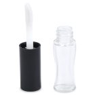 A clear, empty Mini Lip Gloss Bottle with a black cap and a white applicator wand lies next to the open bottle. The angled applicator pairs perfectly with the slightly contoured shape of the bottle for easy handling. The brand name "COMPAX" is visible in the bottom left corner.