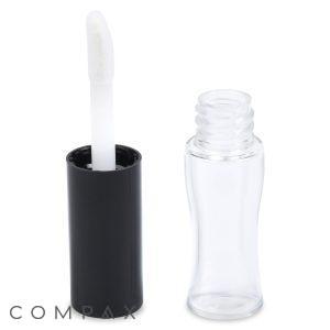 A clear, empty Mini Lip Gloss Bottle with a black cap and a white applicator wand lies next to the open bottle. The angled applicator pairs perfectly with the slightly contoured shape of the bottle for easy handling. The brand name "COMPAX" is visible in the bottom left corner.