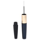 A black Dual Fluted Round Mascara Bottle with a gold accent is pictured with its cap off, revealing the slender brush of the mascara wand. The brand name "COMPAX" is visible in gray text in the bottom left corner. The tube and cap are vertically aligned against a clean white background.