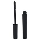 A black mascara tube standing upright with the cap removed and the mascara wand exposed, showing the bristles. The cap is leaning against the tube. The word "COMPAX" is written in the bottom left corner.