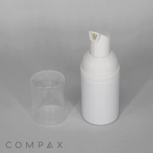 A 30mL Round PET Bottle with a transparent cap placed beside it. The bottle and cap are set against a neutral grey background. The word "COMPAX" is visible in the bottom left corner of the image.