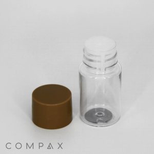 A 15mL round PET bottle, constructed from clear plastic with a small, white dispenser cap. A separate brown screw-on lid lies next to it. The background is plain white, and the word "COMPAX" appears in the bottom left corner.