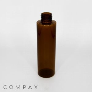 A 150mL Round PET Bottle, tall and cylindrical with a transparent brown color, featuring screw threads for a cap, stands upright against a plain white background. The bottle is empty and the word "COMPAX" is visible at the bottom left corner of the image.