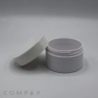 An open 100mL PET Jar with Tall Cap, made of white plastic, is displayed against a plain gray background. The jar, which is empty, is positioned slightly to the right side while its detachable cap leans against it. The word "COMPAX" appears in the bottom left corner of the image.
