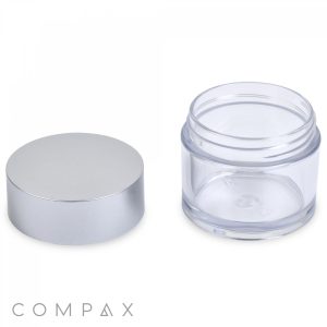 A 50mL PET jar with a silver lid removed, placed side by side on a white background. The transparent cylinder appears to be empty, and the "COMPAX" logo is visible in the bottom left corner.

