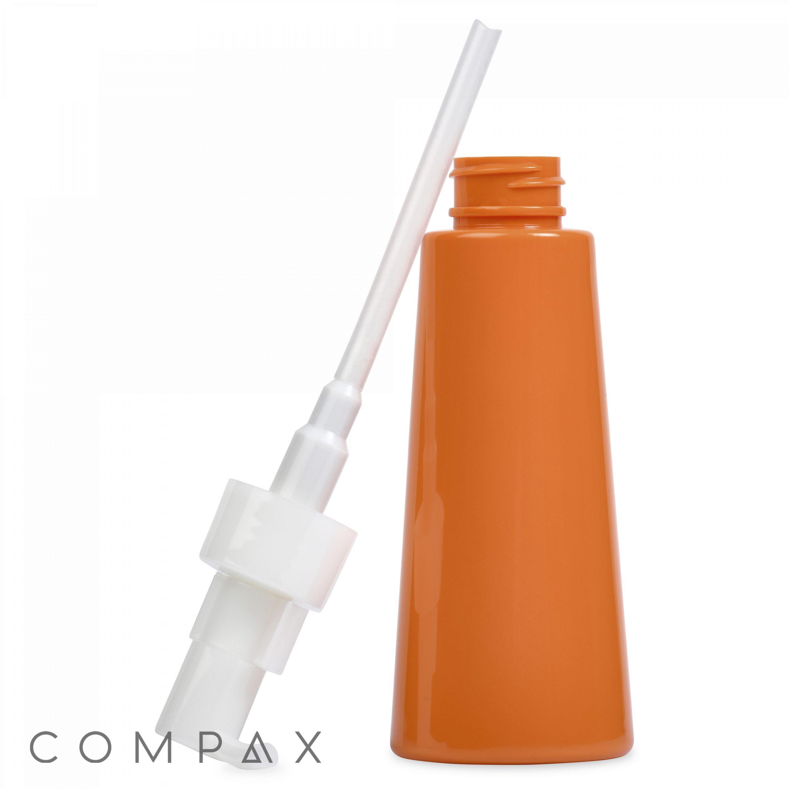 A photograph of a 120 mL PET bottle, orange in color, with a white nozzle applicator beside it. The bottle is positioned upright, and the nozzle features a long, thin tube attached to it. The brand name "COMPAX" is displayed in the bottom left corner.