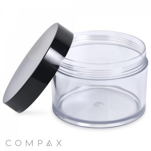 A clear, empty 500mL PET jar with a wide base and a black screw-on lid is shown open. The lid leans against the jar on a white background. The word "COMPAX" is displayed at the bottom left corner.