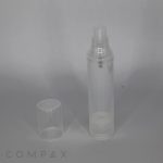 A small, clear Round Recyclable Airless Bottle is depicted with a matching transparent cap placed beside it. The background is a plain, muted grey, and the cylindrical cap fits over the nozzle of the bottle. The bottom part of the bottle is marked with "COMPAX".